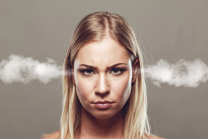 A woman with blonde hair with smoke coming out of her ears