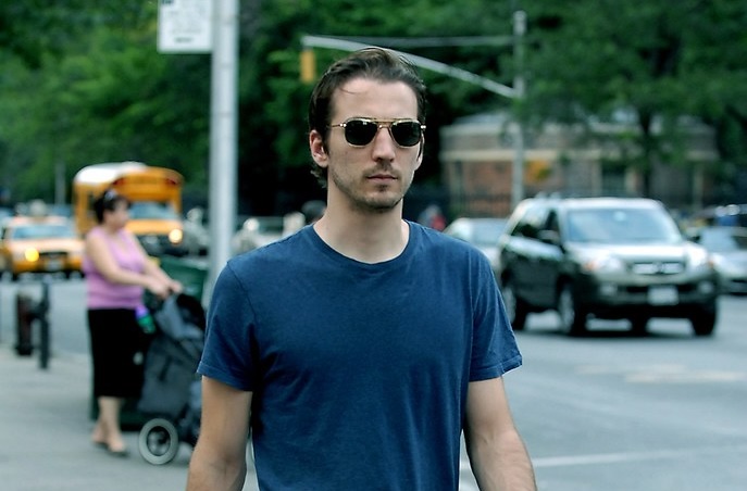 Jamie Johnson in a blue shirt walking on a sidewalk in New York City