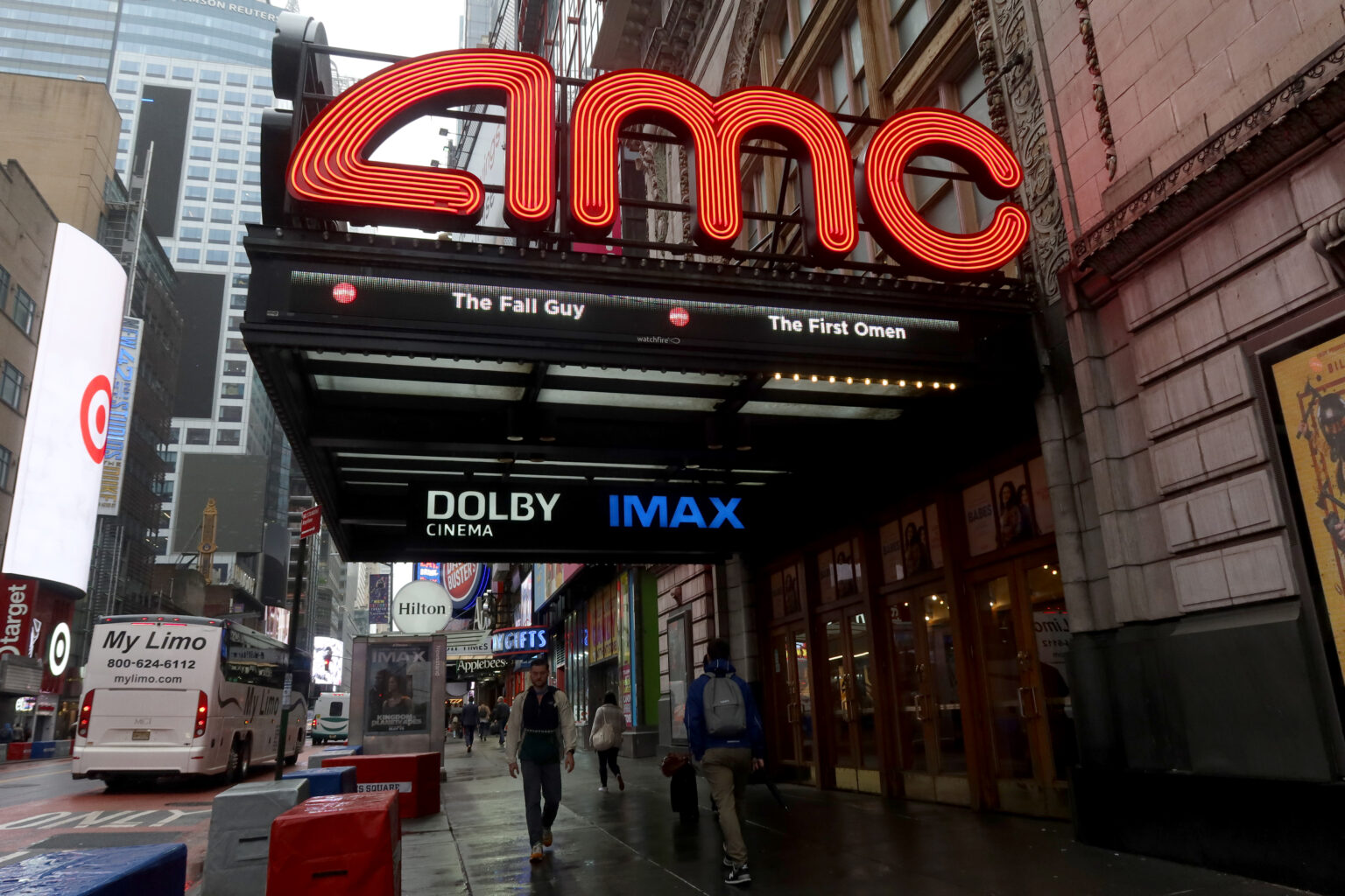 NEW YORK, NY - MAY 16: People walk past an AMC movie theater on 42nd Street in Times Square on May 16, 2024, in New York City.